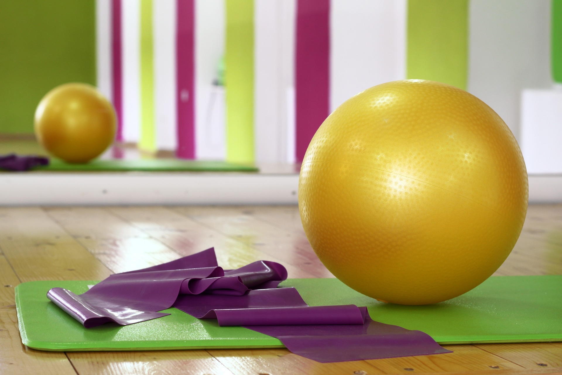 Gymnastikraum Fitnessraum mit einem großen aufblasbaren Sitzball und Yogamatten im Vordergrund.