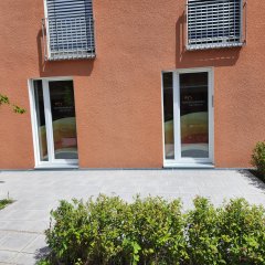 Terrasse des Seniorenbüro Neufahrn mit Schaufenstern im Hintergrund.