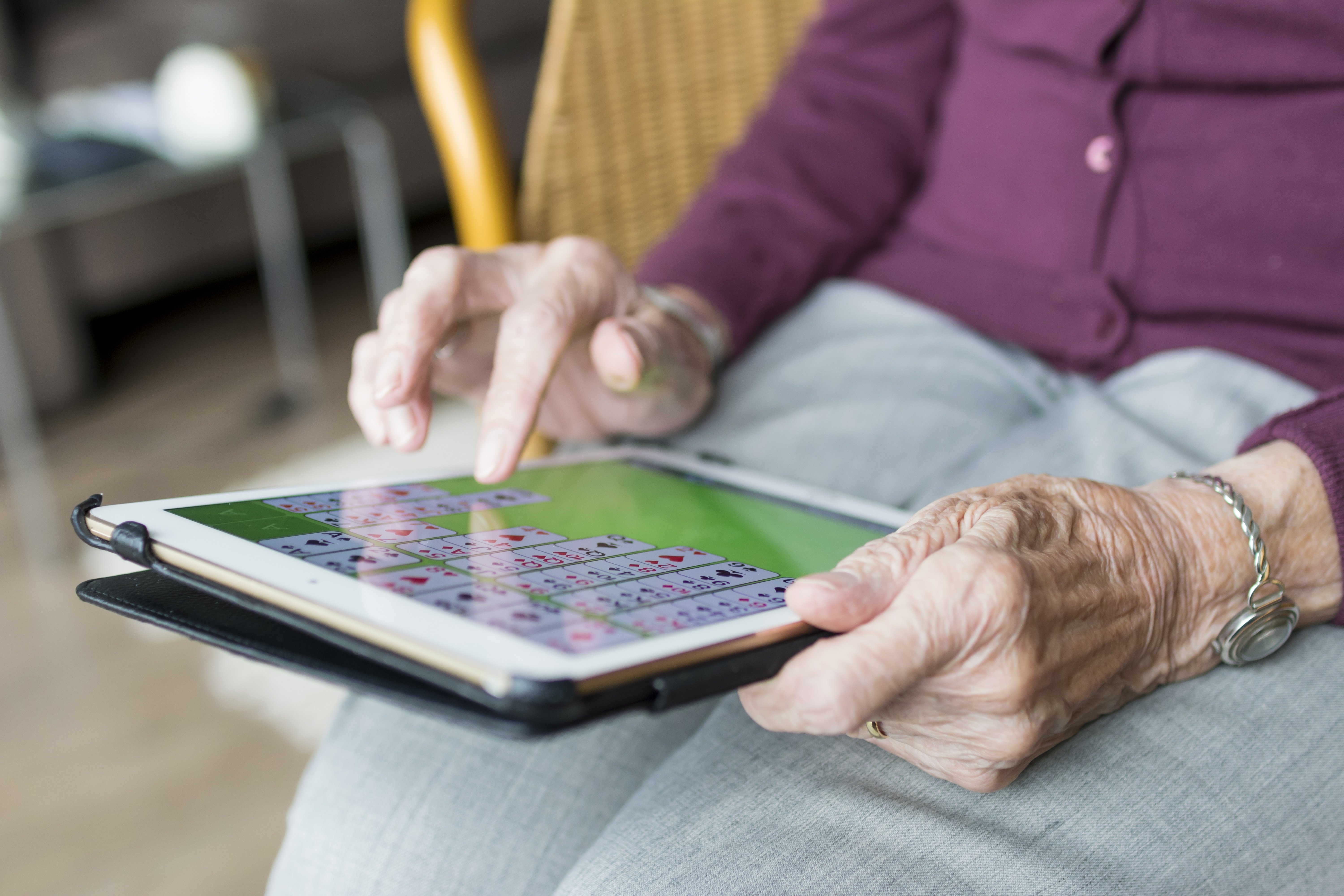 Seniorentablet Seniorin mit Tablet auf dem Schoß