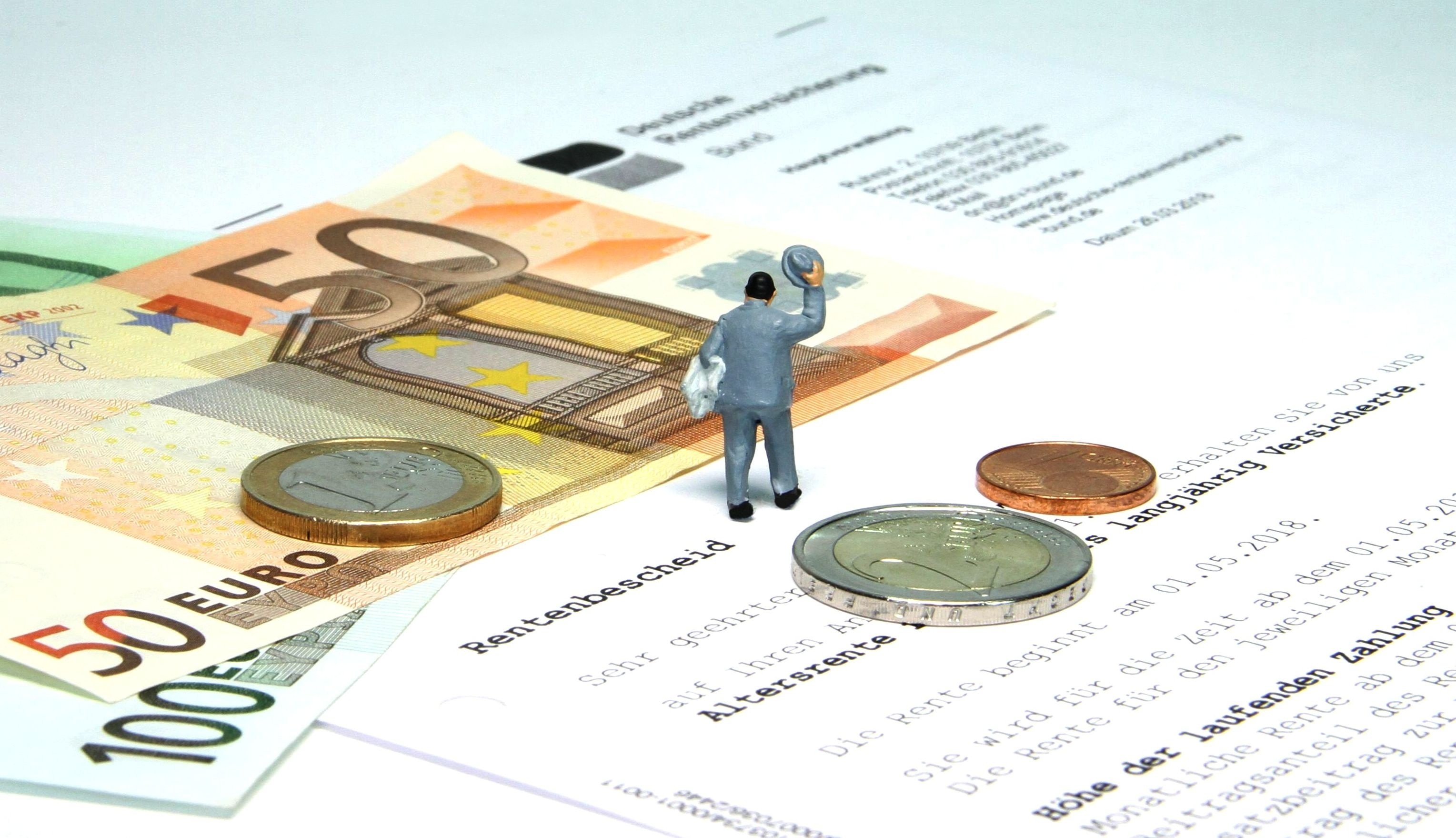 Rente Symbolbild Rente mit Rentenbescheid, Geld und einer Spielfigur